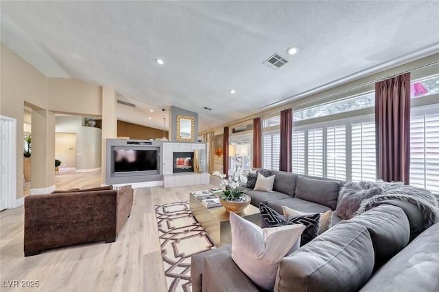 7311 Chaparral Cove Ln, Las Vegas, NV 89131 - living room featuring lofted ceiling, healthy amount of natural light, light wood-style floors, recessed lighting, and a textured ceiling