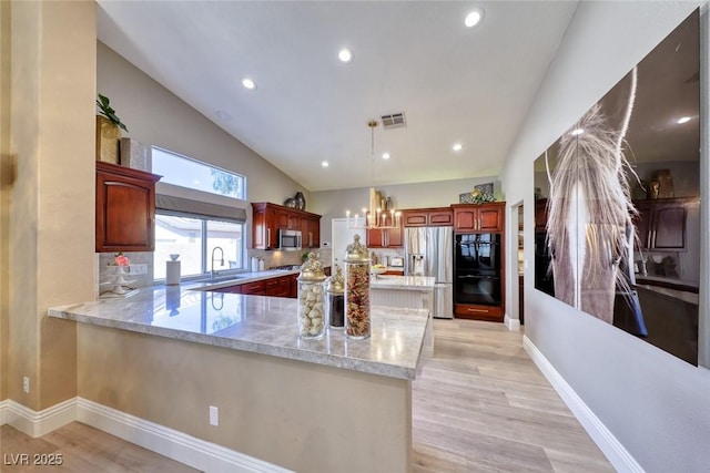 7311 Chaparral Cove Ln, Las Vegas, NV 89131 - kitchen with stainless steel appliances, a peninsula, a chandelier, light wood-style flooring, and recessed lighting
