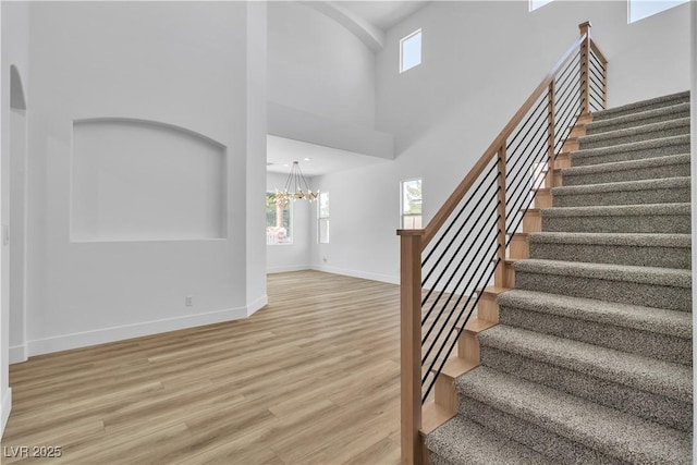 1551 Boundary Peak Way, Las Vegas, NV 89135 - staircase featuring plenty of natural light, a chandelier, wood finished floors, and a high ceiling