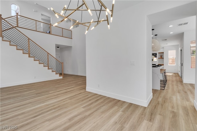 1551 Boundary Peak Way, Las Vegas, NV 89135 - unfurnished living room featuring light wood-style flooring, stairway, healthy amount of natural light, and recessed lighting