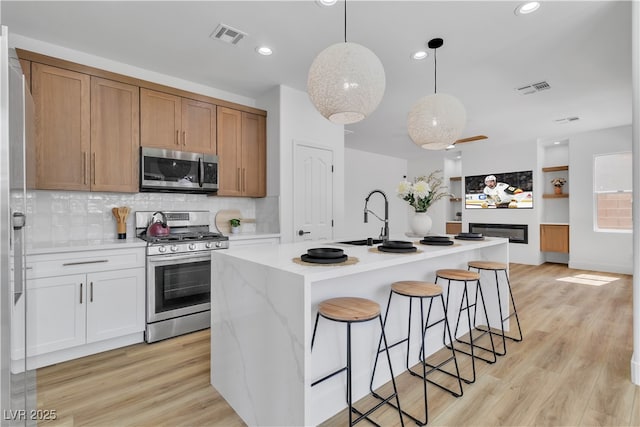 1551 Boundary Peak Way, Las Vegas, NV 89135 - kitchen with stainless steel appliances, light countertops, a breakfast bar, decorative backsplash, and recessed lighting