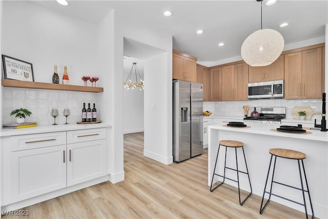 1551 Boundary Peak Way, Las Vegas, NV 89135 - kitchen with stainless steel appliances, backsplash, a breakfast bar, light countertops, and recessed lighting