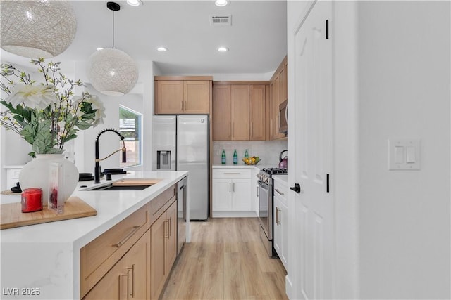 1551 Boundary Peak Way, Las Vegas, NV 89135 - kitchen featuring stainless steel appliances, light wood-style floors, recessed lighting, light countertops, and tasteful backsplash