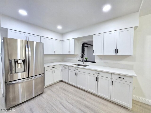 4324 El Conlon Ave, Las Vegas, NV 89102 - kitchen with stainless steel fridge with ice dispenser, light wood finished floors, white cabinets, light countertops, and recessed lighting