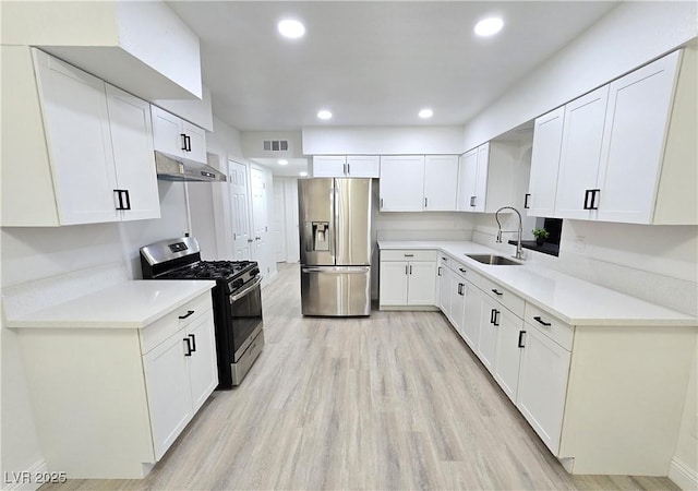 4324 El Conlon Ave, Las Vegas, NV 89102 - kitchen featuring stainless steel appliances, under cabinet range hood, white cabinetry, light wood-style floors, and light countertops
