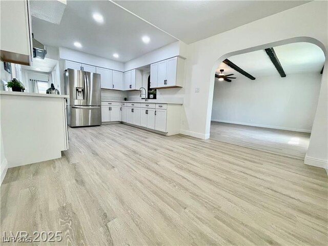 4324 El Conlon Ave, Las Vegas, NV 89102 - kitchen with stainless steel refrigerator with ice dispenser, a ceiling fan, light wood-style floors, arched walkways, and light countertops