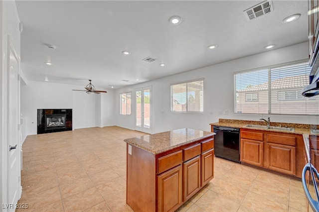 2261 Dalton Ridge Ct, North Las Vegas, NV 89031 - kitchen with dishwasher, ceiling fan, light stone counters, brown cabinets, and recessed lighting