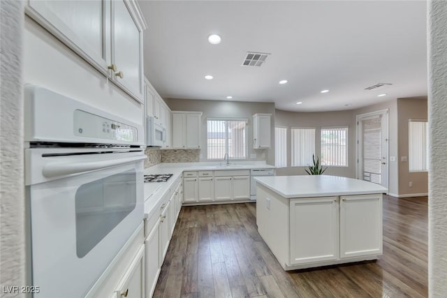7606 Kenwood Hills Ct, Las Vegas, NV 89131 - kitchen with white appliances, a kitchen island, white cabinetry, dark wood-style floors, and light countertops