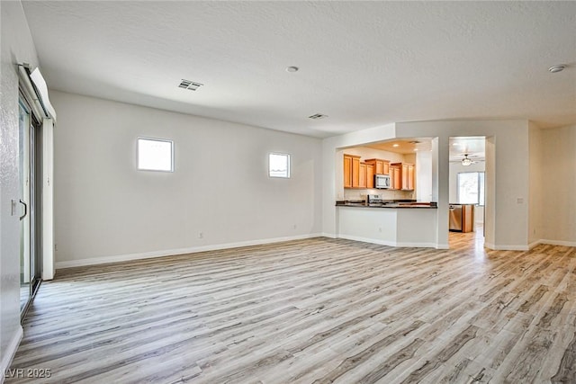 5967 Sun Appello Ave, Las Vegas, NV 89122 - unfurnished living room with light wood finished floors, a textured ceiling, and ceiling fan