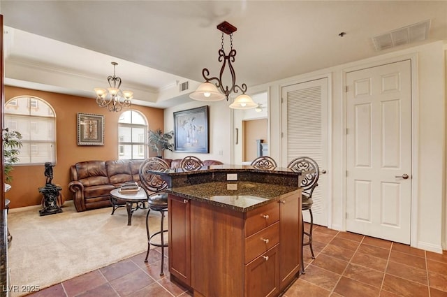 2405 W Serene Ave Unit 612, Las Vegas, NV 89123 - kitchen with a kitchen breakfast bar, a raised ceiling, dark tile patterned flooring, brown cabinetry, and crown molding