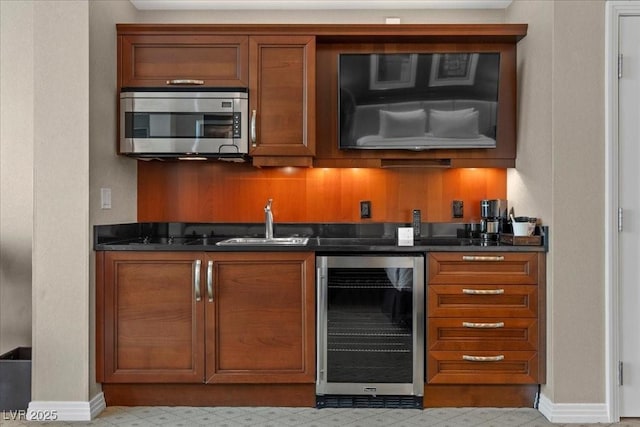 135 E Harmon Ave Unit 3816, Las Vegas, NV 89109 - kitchen featuring wine cooler, stainless steel microwave, dark countertops, and brown cabinetry