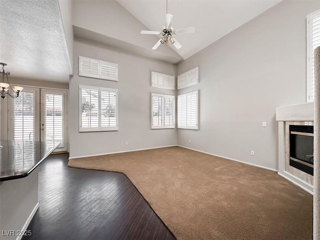 8612 Chiquita Dr, Las Vegas, NV 89128 - unfurnished living room featuring a ceiling fan, a chandelier, high vaulted ceiling, carpet floors, and a glass covered fireplace
