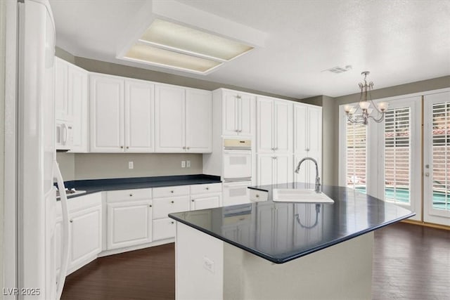 8612 Chiquita Dr, Las Vegas, NV 89128 - kitchen with white appliances, dark countertops, dark wood finished floors, and white cabinetry