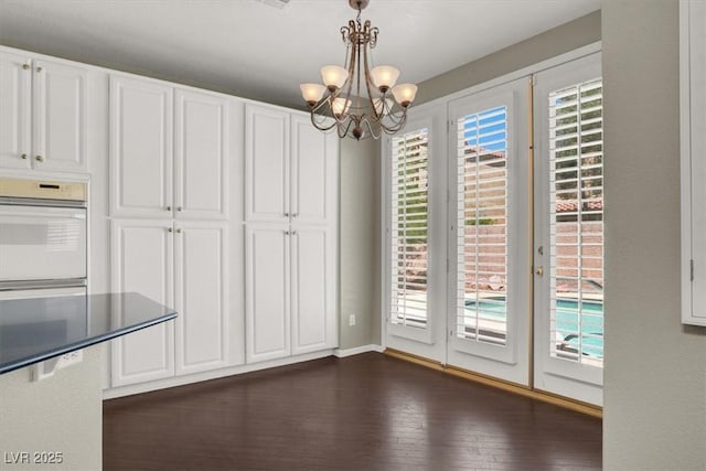 8612 Chiquita Dr, Las Vegas, NV 89128 - unfurnished dining area with a chandelier and dark wood-style floors
