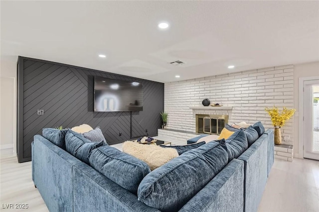3047 Van Buskirk Cir, Las Vegas, NV 89121 - living area featuring light wood finished floors, recessed lighting, a fireplace, and an accent wall