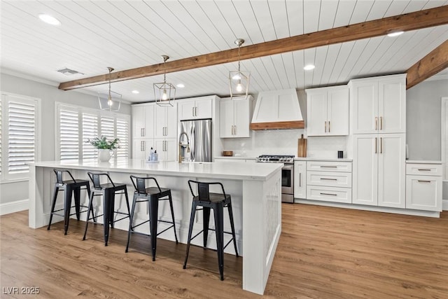 8820 Fall Green Ave, Las Vegas, NV 89129 - kitchen with appliances with stainless steel finishes, custom exhaust hood, a kitchen breakfast bar, recessed lighting, and white cabinetry