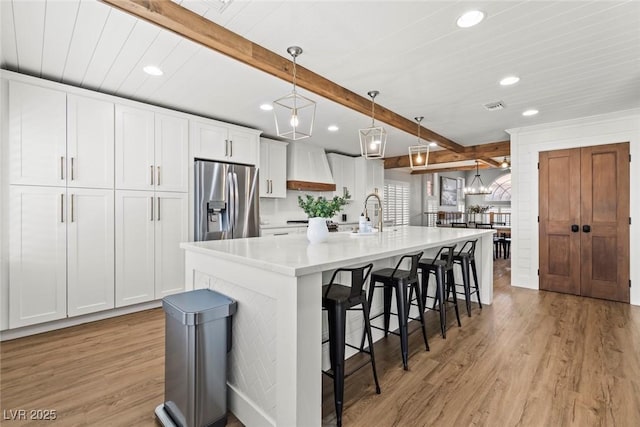 8820 Fall Green Ave, Las Vegas, NV 89129 - kitchen with stainless steel fridge with ice dispenser, light wood-style floors, beamed ceiling, recessed lighting, and white cabinetry