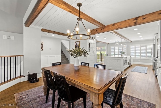 8820 Fall Green Ave, Las Vegas, NV 89129 - dining area featuring wood finished floors, beam ceiling, a chandelier, stairway, and a wainscoted wall
