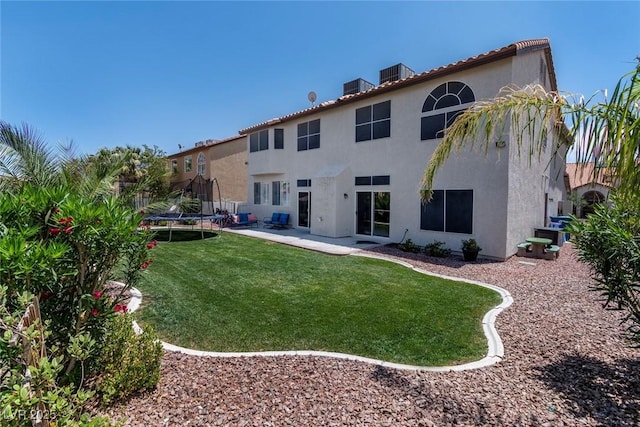 8820 Fall Green Ave, Las Vegas, NV 89129 - rear view of house with a trampoline, stucco siding, a lawn, and a patio
