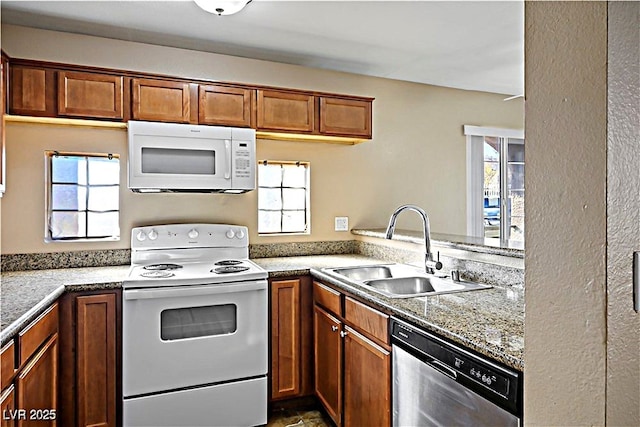 2101 Sealion Dr Unit 108, Las Vegas, NV 89128 - kitchen with white appliances, brown cabinetry, and healthy amount of natural light