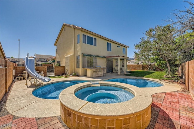 3624 Snowy Pines St, Las Vegas, NV 89147 - view of swimming pool featuring a water slide, a fenced backyard, a patio area, and a pool with connected hot tub
