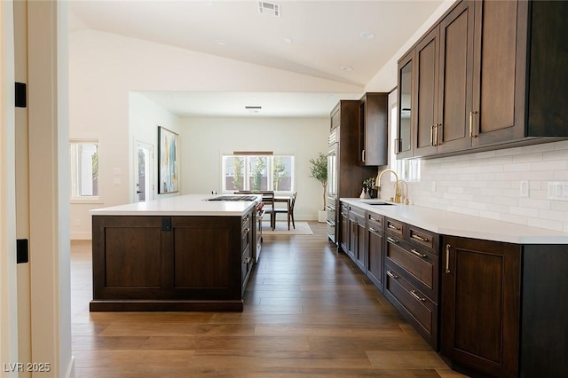 7745 Radcliff St, Las Vegas, NV 89123 - kitchen featuring lofted ceiling, light countertops, a kitchen island with sink, and dark brown cabinetry