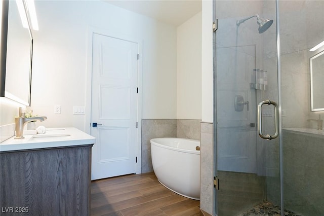 7745 Radcliff St, Las Vegas, NV 89123 - full bathroom featuring vanity, a shower stall, wood finished floors, a freestanding tub, and wainscoting