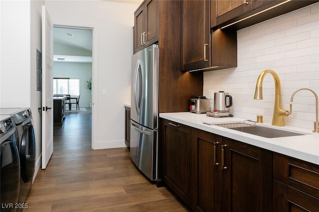 7745 Radcliff St, Las Vegas, NV 89123 - kitchen featuring freestanding refrigerator, washing machine and dryer, tasteful backsplash, dark wood finished floors, and light countertops