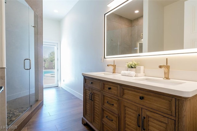 7745 Radcliff St, Las Vegas, NV 89123 - bathroom featuring a shower stall, double vanity, wood finished floors, and recessed lighting