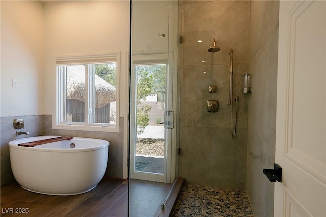 7745 Radcliff St, Las Vegas, NV 89123 - full bathroom featuring wood finished floors, a freestanding tub, a stall shower, and tile walls