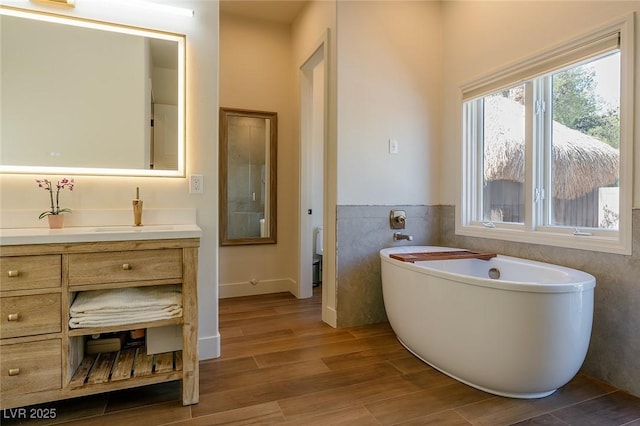 7745 Radcliff St, Las Vegas, NV 89123 - full bath featuring a soaking tub, vanity, wood finished floors, and tile walls