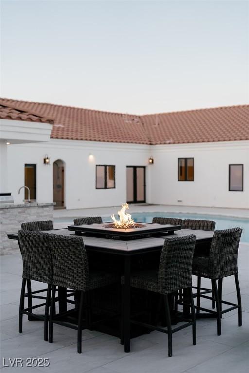 7745 Radcliff St, Las Vegas, NV 89123 - back of property featuring an outdoor fire pit and stucco siding