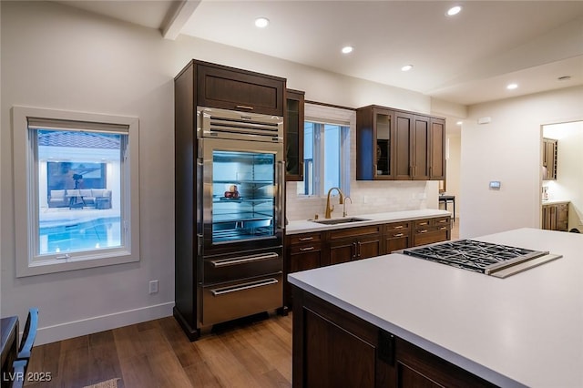 7745 Radcliff St, Las Vegas, NV 89123 - kitchen with refrigerator, cooktop, tasteful backsplash, dark wood-type flooring, and light countertops