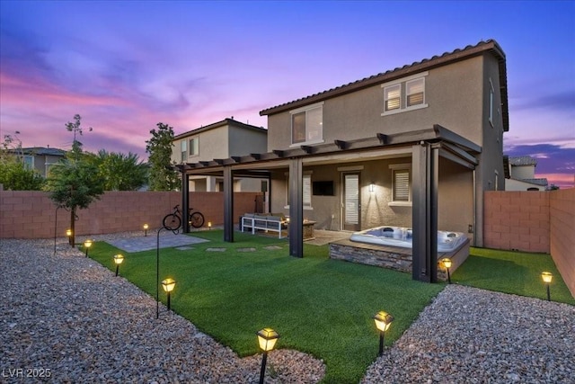 8013 Green River Knob St, Las Vegas, NV 89113 - back of property at dusk with stucco siding, a fenced backyard, a hot tub, and a patio area