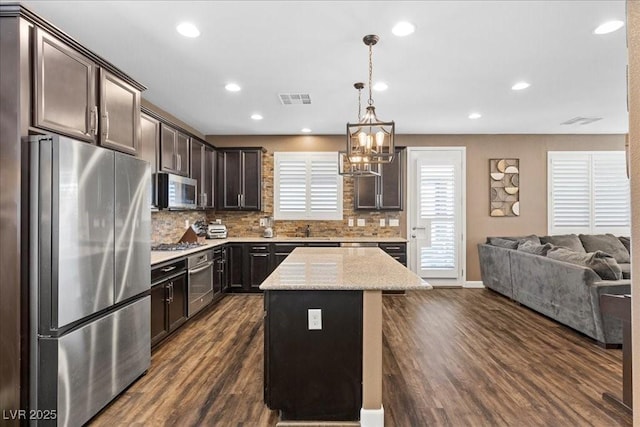 8013 Green River Knob St, Las Vegas, NV 89113 - kitchen with stainless steel appliances, open floor plan, dark wood finished floors, dark brown cabinetry, and backsplash