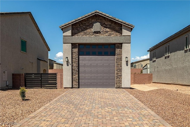 8753 Mann St, Las Vegas, NV 89139 - view of front of house featuring stone siding, decorative driveway, stucco siding, and a tile roof