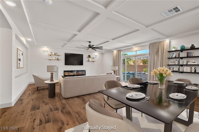 8753 Mann St, Las Vegas, NV 89139 - dining area featuring wood finished floors, coffered ceiling, a ceiling fan, a glass covered fireplace, and beam ceiling