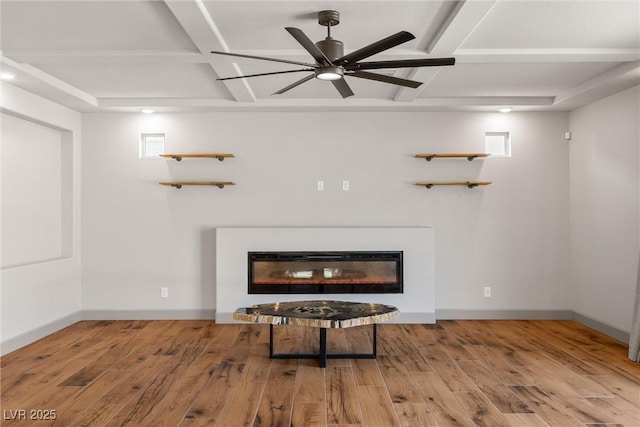 8753 Mann St, Las Vegas, NV 89139 - unfurnished living room with coffered ceiling, a glass covered fireplace, wood finished floors, ceiling fan, and beam ceiling