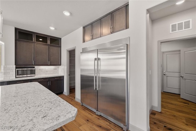 8753 Mann St, Las Vegas, NV 89139 - kitchen featuring stainless steel appliances, dark brown cabinets, decorative backsplash, hardwood / wood-style floors, and recessed lighting