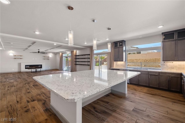 8753 Mann St, Las Vegas, NV 89139 - kitchen featuring a kitchen island, dark wood-type flooring, light stone counters, open floor plan, and recessed lighting