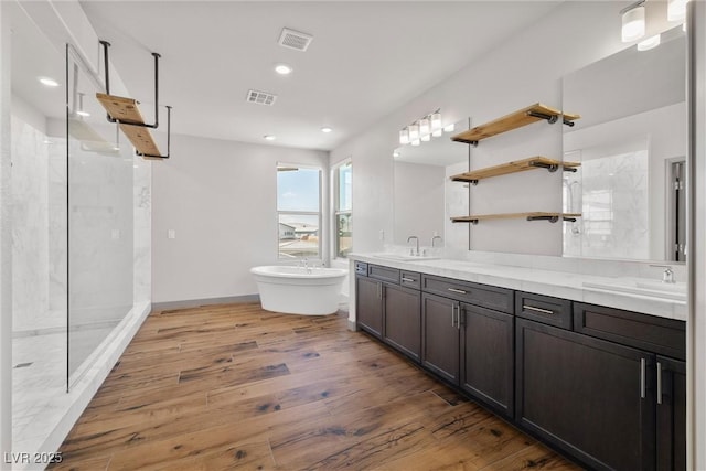 8753 Mann St, Las Vegas, NV 89139 - bathroom with a marble finish shower, double vanity, a freestanding bath, wood finished floors, and recessed lighting