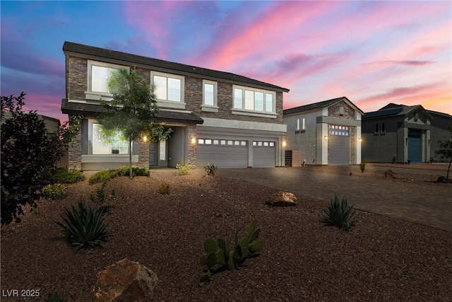 8753 Mann St, Las Vegas, NV 89139 - view of front of house featuring stone siding, driveway, and an attached garage