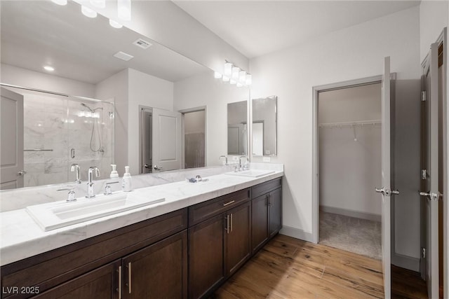 8753 Mann St, Las Vegas, NV 89139 - full bathroom with a shower stall, double vanity, wood finished floors, and a spacious closet