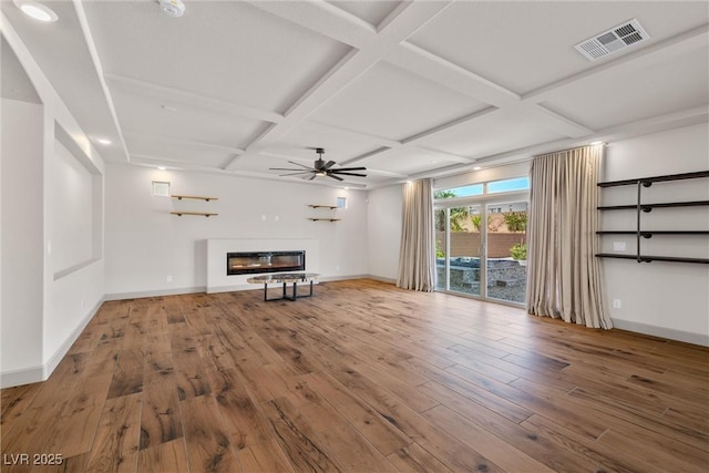 8753 Mann St, Las Vegas, NV 89139 - unfurnished living room featuring coffered ceiling, wood finished floors, a ceiling fan, a glass covered fireplace, and beamed ceiling