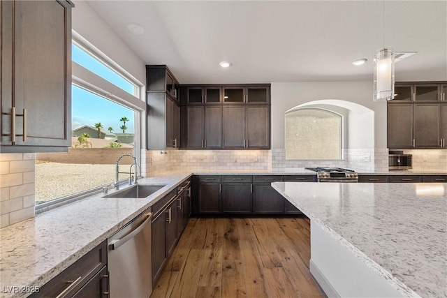 8753 Mann St, Las Vegas, NV 89139 - kitchen with stainless steel appliances, light stone countertops, tasteful backsplash, glass insert cabinets, and recessed lighting