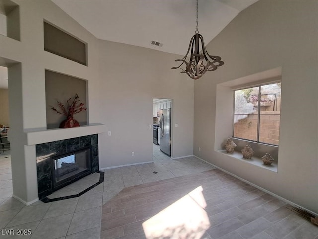 13 Desert Dawn Ln, Henderson, NV 89074 - unfurnished living room featuring high vaulted ceiling, tile patterned flooring, a chandelier, and a high end fireplace