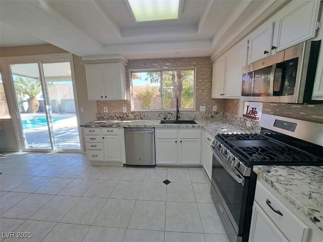 13 Desert Dawn Ln, Henderson, NV 89074 - kitchen featuring stainless steel appliances, a raised ceiling, tasteful backsplash, and light tile patterned floors