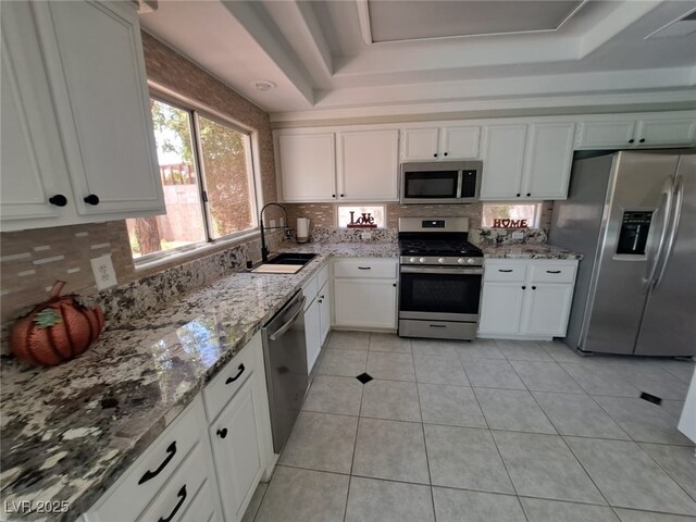 13 Desert Dawn Ln, Henderson, NV 89074 - kitchen with stainless steel appliances, decorative backsplash, white cabinets, and light stone countertops
