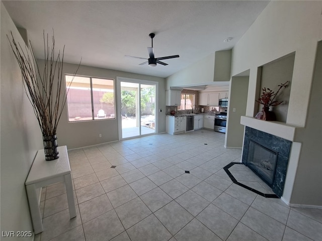 13 Desert Dawn Ln, Henderson, NV 89074 - unfurnished living room with a ceiling fan, light tile patterned flooring, lofted ceiling, and a high end fireplace