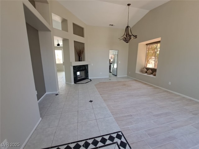 13 Desert Dawn Ln, Henderson, NV 89074 - unfurnished living room featuring light tile patterned flooring, a chandelier, high vaulted ceiling, and a high end fireplace